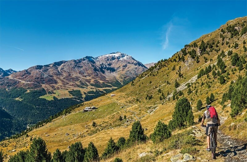 Cycling towards the Ables Huts. On the left, the imposing Pizzo Tresero, in the background Mount Sobretta.
