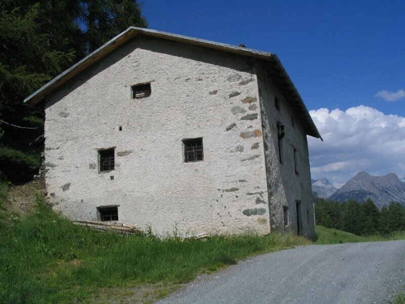 A stone cottage and walls next to the path